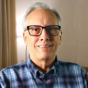 Smiling older man with gray hair and glasses